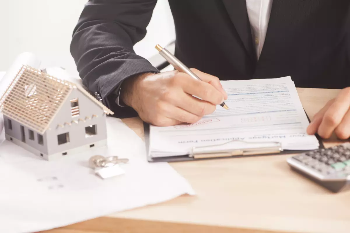 PLF 2026 les différents amendements – une maquette de maison et un conrat en signature