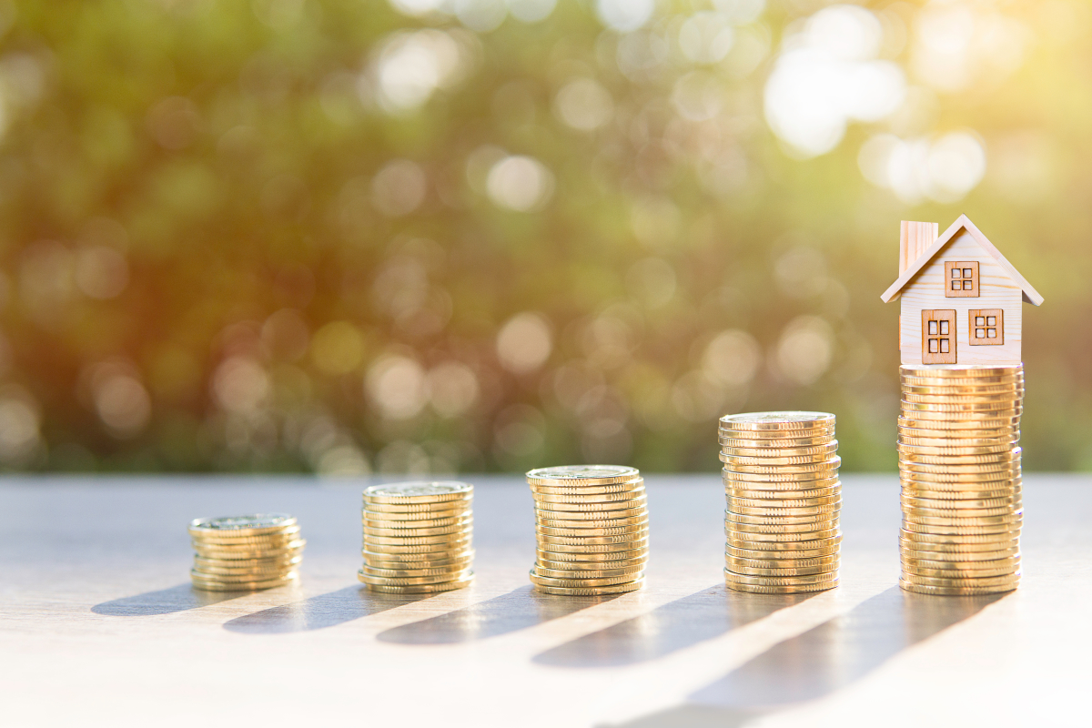 Quelles sont les clés d'un investissement en colocation réussi ? piles de monnaie devant une maison miniature