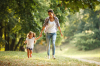 Végétalisation à Toulouse – Une mère et sa fille se promenant dans un parc boisé