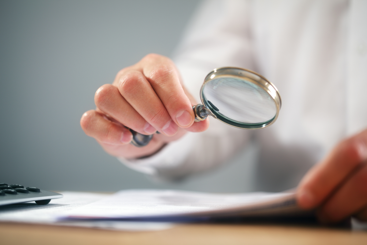 Les points de vigilance à passer au crible avant de signer un contrat de réservation un expert examine un contrat à la loupe