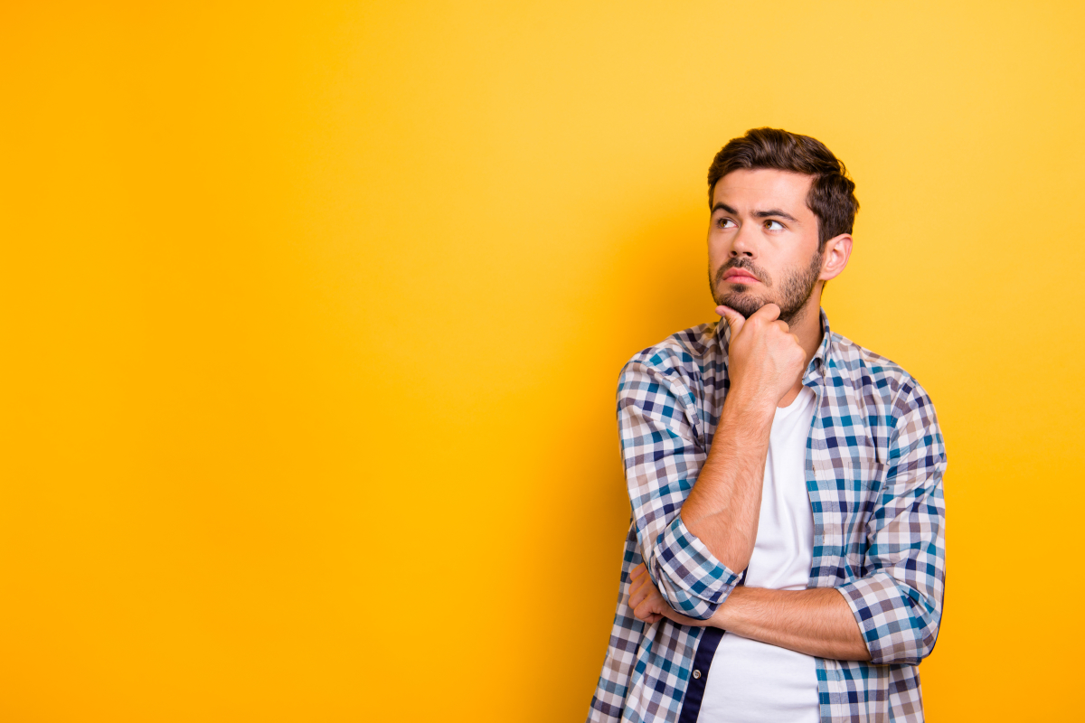 Questions fréquentes sur le contrat de réservation Un homme en plein questionnement sur fond jaune