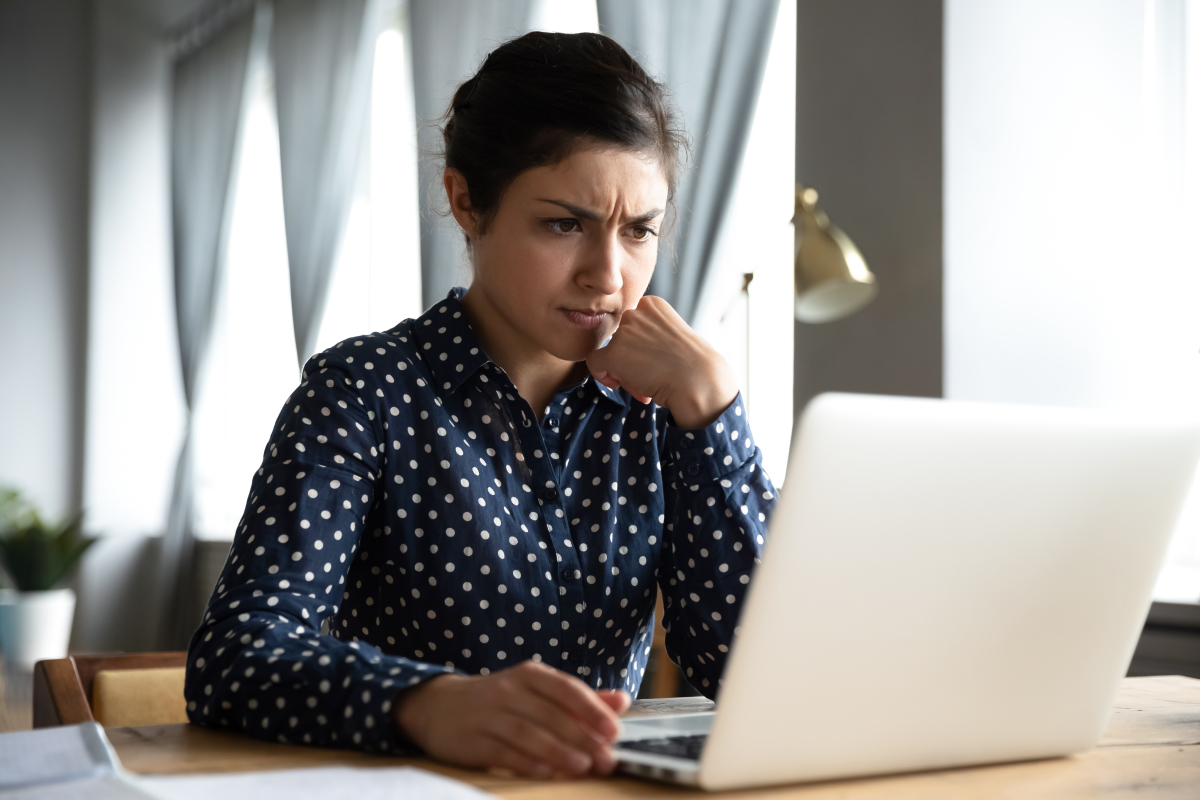 Commercialisateur immobilier neuf– Une femme en réflexion devant son ordinateur